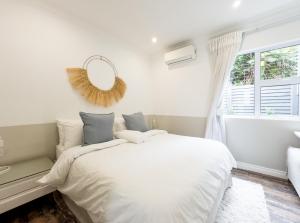 德班Secure, Peaceful Modern Cottage for Two的白色的卧室设有床和窗户