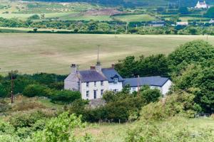 阿姆奇Superb Location - 'The Annexe' - at Ty Moel Isaf的田野中间的白色房子