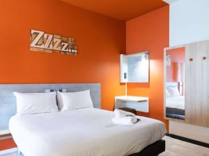 马德里ibis budget Madrid Aeropuerto的一间卧室配有一张带橙色墙壁的大床