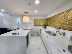 济州市哈尼豪斯度假屋的白色的厨房设有水槽和台面