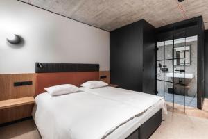卡托维兹Qubus Hotel Katowice的一间卧室设有一张大床和一个水槽