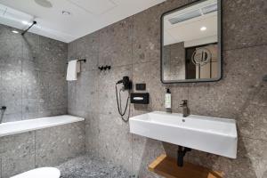 卡托维兹Qubus Hotel Katowice的一间带水槽和镜子的浴室