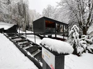 诺茨瓦约Blackbox House Noszvaj的雪上雪的黑色建筑