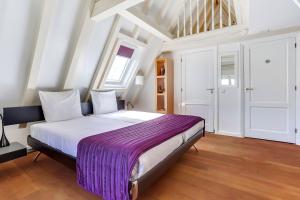 阿姆斯特丹City-centre, Canal-house, luxurious , stylish bedroom, ensuite bathroom, own entrance的一间卧室配有一张大床和紫色毯子