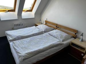 小莫拉夫卡Hotel Figura的一间卧室配有一张带白色床单的床和两个窗户。