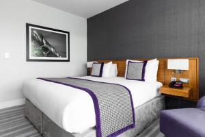 泰恩河畔纽卡斯尔纽卡斯尔皇冠假日酒店 - 史蒂芬森区的酒店客房带一张大床和一把椅子