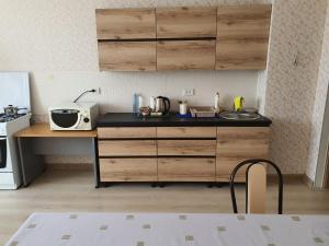 阿克托比2-ух комнатная квартира Юнис Сити г.Актобе的厨房配有木制橱柜和台面