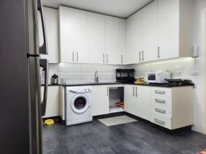 贝鲁特Charming 2BR Gemayze的厨房配有白色橱柜和洗衣机。