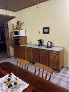尚格里拉Casa Família Mattos的厨房配有桌子和带微波炉的台面