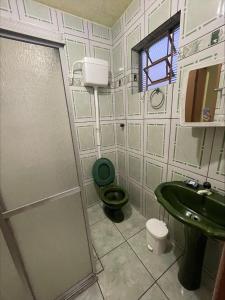 尚格里拉Casa Família Mattos的浴室配有绿色卫生间和水槽。