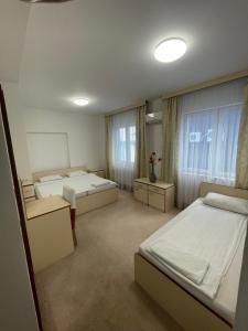 萨拉热窝阿达 - 奥托卡酒店的一间卧室设有两张床和两个窗户。