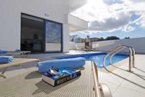 普罗塔拉斯Villa Genesis的一座带游泳池的房子和一本书