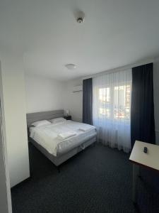 萨拉热窝阿达 - 奥托卡酒店的卧室配有白色的床和窗户。