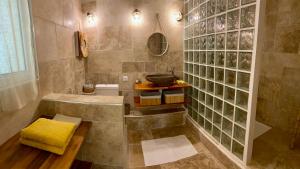 圣若瑟La Case O zoizos的浴室配有浴缸和带黄毛巾的盥洗盆。