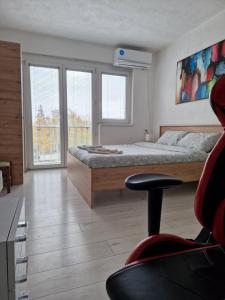 库马诺沃City Square Apartment的一间卧室配有一张床、一张桌子和一把椅子