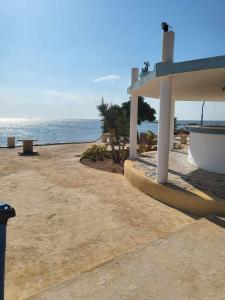 Sidi el MoujahedBeach Houses Kerkennah perfect for couples的海滩上的凉亭,背靠大海