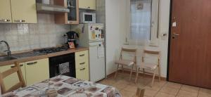 卡利亚里Casa di Eloisa的厨房配有冰箱和桌椅