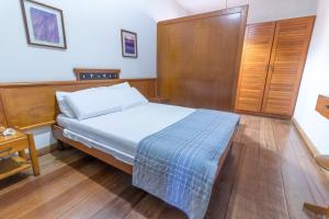 塞拉Praia Sol Hotel by Castelo Itaipava的一间卧室配有一张床和一个木制橱柜