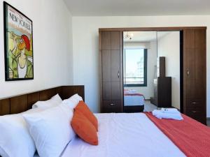 贝鲁特Elevated 2BR living in Hamra的卧室配有一张带白色床单和橙色枕头的大床。