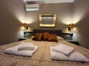 帕尔马诺瓦Hotel Roma的一间卧室配有一张带两个枕头和镜子的床