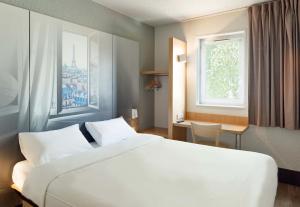 维勒班特B&B HOTEL Paris Nord Villepinte的卧室设有一张白色大床和一扇窗户。