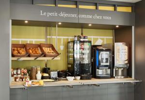 维勒班特B&B HOTEL Paris Nord Villepinte的厨房配有带咖啡壶和面包的柜台。