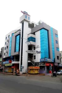索拉普Hotel Vaishnavi的城市街道上一座带蓝色窗户的大型建筑