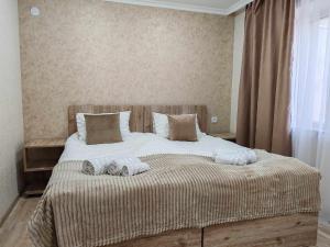 叶海格纳佐尔Sun House的一间卧室配有一张大床和毛巾