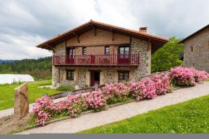 Murueta-OrozkoCasa Rural Etxegorri的前面有粉红色花的房子