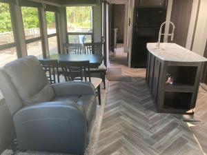 卡文迪西Cavendish Luxury Camping的带沙发和桌子的客厅以及厨房。
