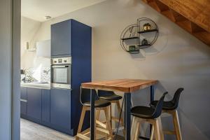 坎佩尔Le Duplex, proche centre-ville的厨房配有蓝色橱柜、木桌和凳子