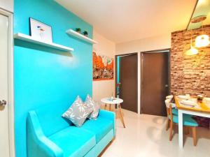 公主港Palawan Paradise Condotel 1L的客厅配有一张蓝色的沙发,配有一张桌子