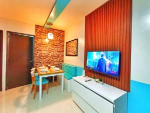 公主港Palawan Paradise Condotel 1L的客厅配有桌子,墙上配有电视