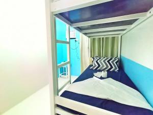 公主港Palawan Paradise Condotel 1L的一间小卧室,配有蓝色和白色的双层床