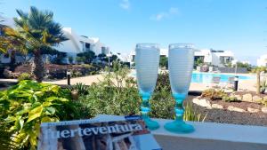 维拉韦德Casa Ana - Luxury pool apartment at Casilla de Costa的两杯酒杯坐在桌旁的游泳池边