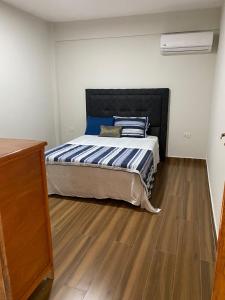 恩卡纳西翁Apartamentos IVAGO的一间卧室配有一张床,铺有木地板