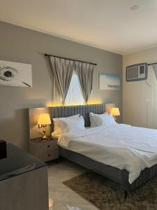 海米斯穆谢特شقق ثمانين بارك1的卧室配有一张带白色床单和枕头的大床。