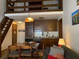 苏尔勒吉Apartment Residenza Chesa Margun 59-6 by Interhome的厨房以及带桌子和沙发的用餐室。