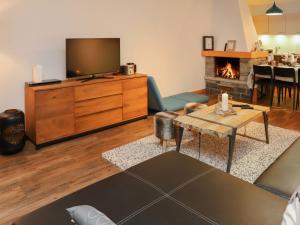 南达查多姿24-1公寓的一间带电视和壁炉的客厅