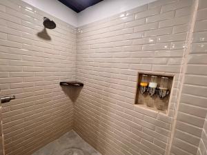 RiversdaleLa Vida Belize - Studio的浴室内铺有白色瓷砖并配有3把蜡烛的淋浴间