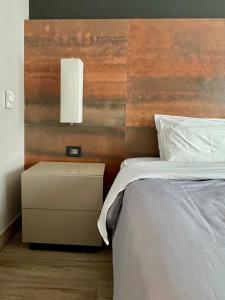 圣保罗Flat particular incrível dentro do hotel M Ibirapuera em Moema的一间卧室配有一张床和一个带白色床罩的床头柜。