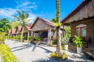 富国Mai Phuong Resort Phu Quoc的前面有棕榈树的房子