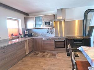 希帕赫Holiday Home Pfundshof by Interhome的厨房配有木制橱柜和不锈钢用具