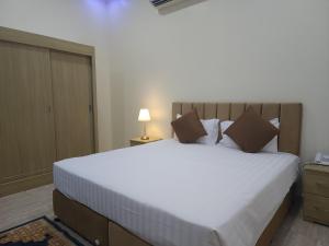 索哈尔Sohar Hotel - فندق صحار的卧室配有一张白色大床