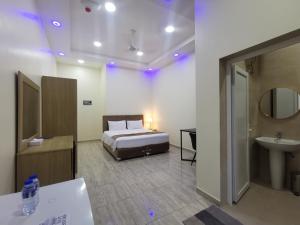 索哈尔Sohar Hotel - فندق صحار的一间卧室配有床和水槽,还有一间浴室