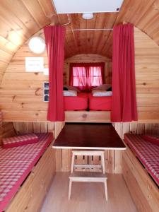 埃希特纳赫Camping Officiel Wollefsschlucht Echternach的一间小房子里带两张床和一张桌子的房间