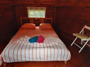 埃希特纳赫Camping Officiel Wollefsschlucht Echternach的一张带两顶帽子和椅子的床