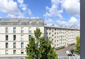 兰斯B&B HOTEL Reims Centre Gare的公寓大楼前面有一棵树