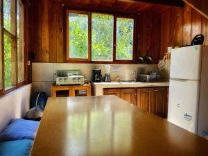 明多Inti Mindo Hostel的厨房配有桌子和冰箱
