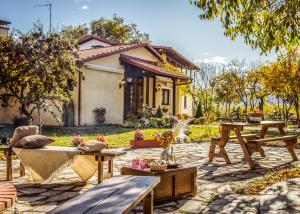 纳乌萨玛西亚斯维拉安瑟米亚酒店的房屋前设有带长凳和桌子的庭院。